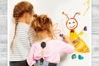 kleine Mädchen zeichnen etwas an eine Tafel